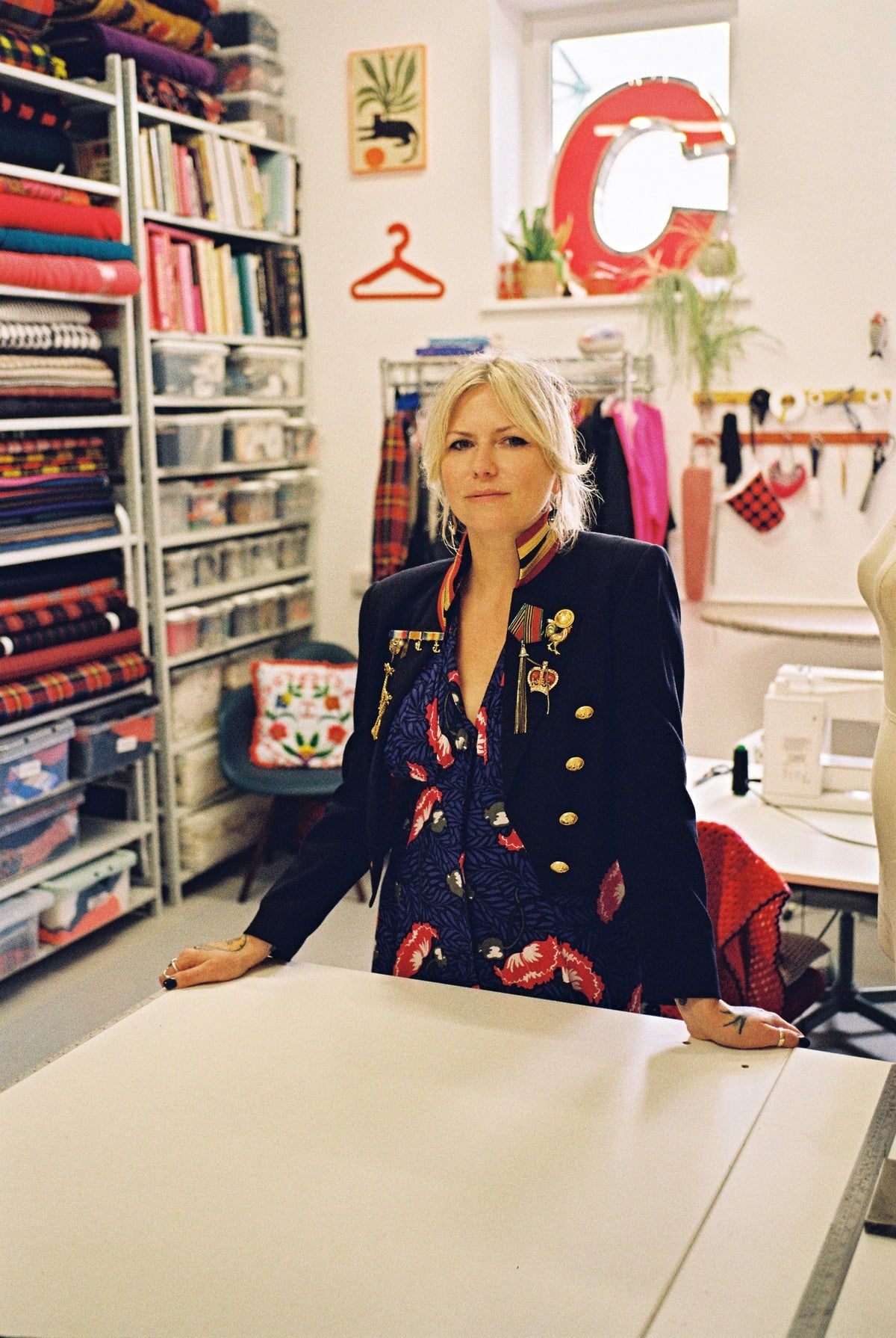 Designer Holly Campbell in a navy military jacket at her cutting table