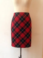 A bias cut tartan pencil skirt displayed on a mannequin, featuring a red and black checkered pattern.