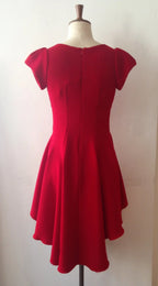 A red dress with cap sleeves and a flowing hemline displayed on a mannequin.