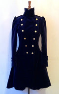 A navy velvet frock coat with double-breasted design and brass dome buttons, displayed on a mannequin.